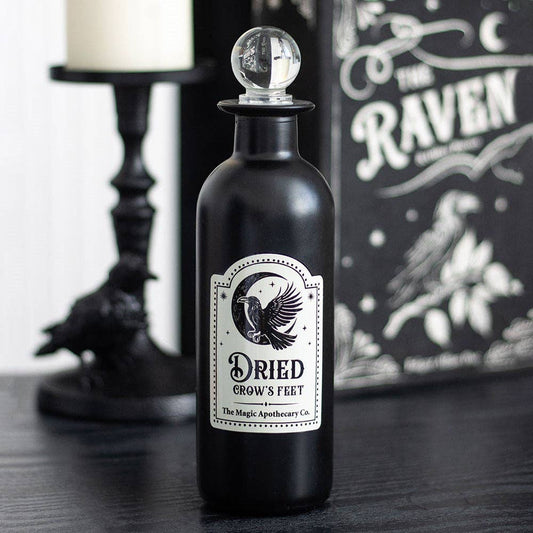 Bouteille de potion en verre gothique décorative avec pattes d'oie séchées
